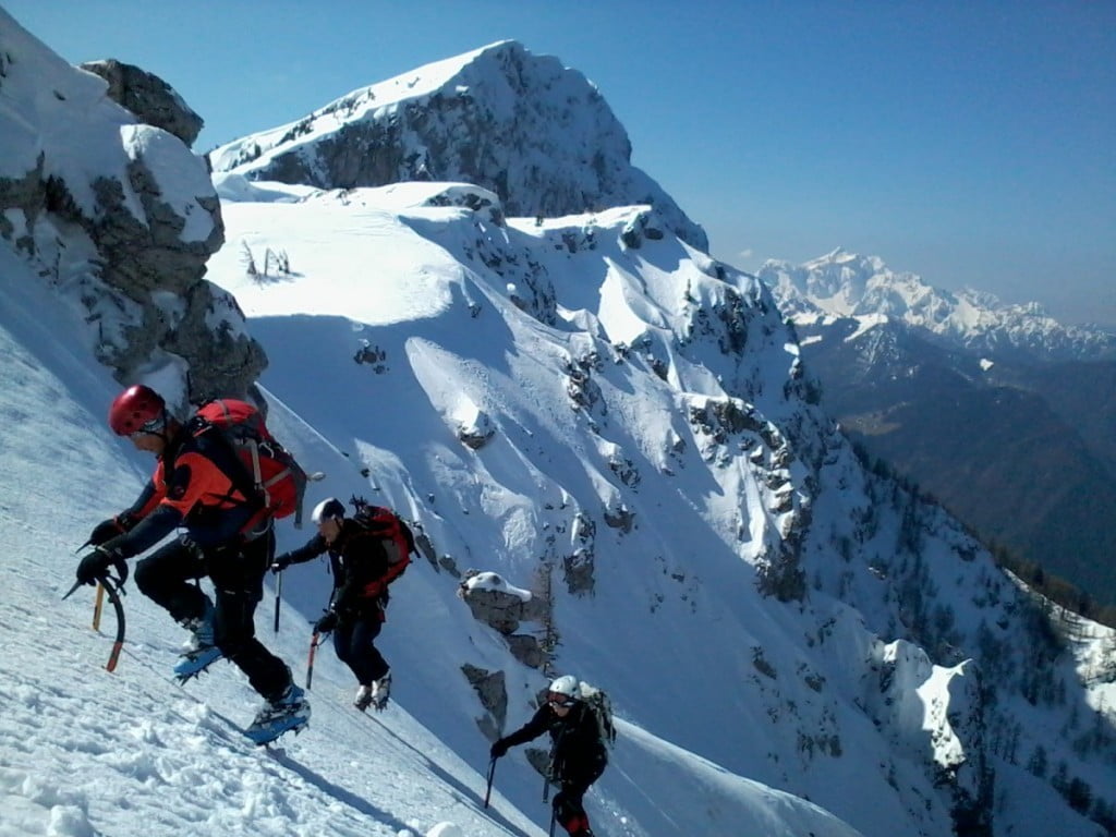 Alpinisti plezajo iz grap Laneža, zadaj Raduha in Kamniško-Savinjske Alpe