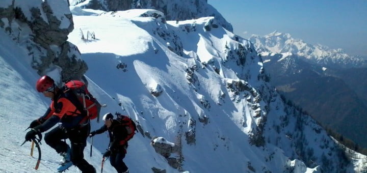 Alpinisti plezajo iz grap Laneža, zadaj Raduha in Kamniško-Savinjske Alpe
